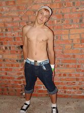 Jorts and baseball cap stylish twink posing half-naked