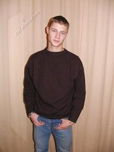 Brown-haired twink smiling and posing on the floor