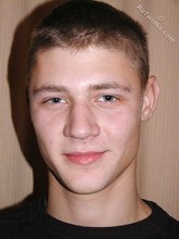 Brown-haired twink smiling and posing on the floor