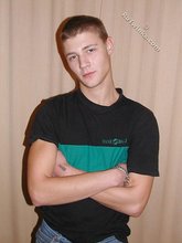 Brown-haired twink smiling and posing on the floor