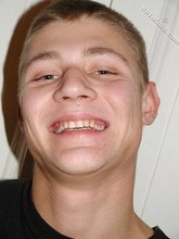 Brown-haired twink smiling and posing on the floor
