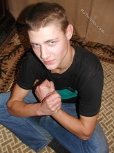 Brown-haired twink smiling and posing on the floor