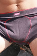 Cheerful dark-haired twink showing off his toned ass