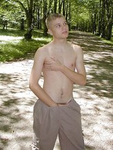 Blue-eyed and baby-faced twink undressing outdoors