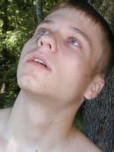 Blue-eyed twink boy posing completely naked outdoors