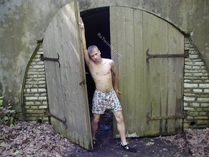 Blue-eyed twink boy posing completely naked outdoors