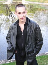 Serious-looking twink takes off his shirt outdoors