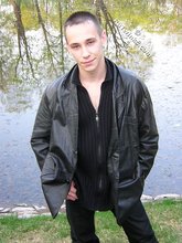 Serious-looking twink takes off his shirt outdoors