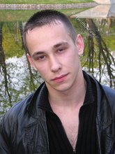 Serious-looking twink takes off his shirt outdoors