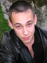 Serious-looking twink takes off his shirt outdoors