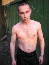 Serious-looking twink takes off his shirt outdoors