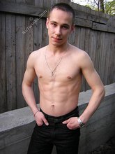 Serious-looking twink takes off his shirt outdoors