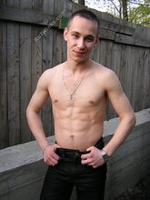 Serious-looking twink takes off his shirt outdoors