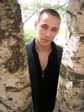 Serious-looking twink takes off his shirt outdoors