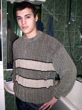 Sweater-wearing brunette boy undressing on camera