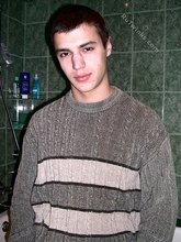 Sweater-wearing brunette boy undressing on camera