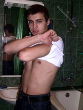Sweater-wearing brunette boy undressing on camera
