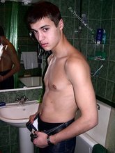 Sweater-wearing brunette boy undressing on camera