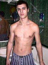 Sweater-wearing brunette boy undressing on camera