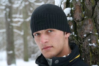 Beautiful young boy posing outdoors with trees