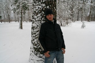 Beautiful young boy posing outdoors with trees