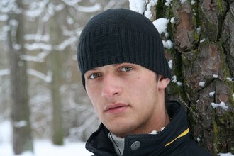 Beautiful young boy posing outdoors with trees