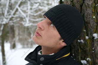 Beautiful young boy posing outdoors with trees