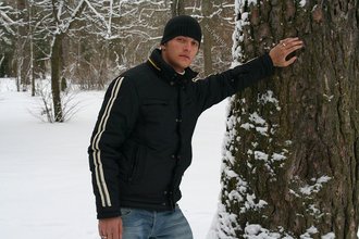 Beautiful young boy posing outdoors with trees