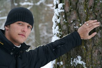 Beautiful young boy posing outdoors with trees