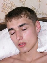 Blue-eyed brunette twink masturbating with his legs spread