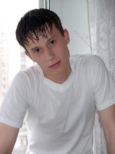 Sweaty/greasy-looking twink undressing next to a window