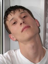 Sweaty/greasy-looking twink undressing next to a window