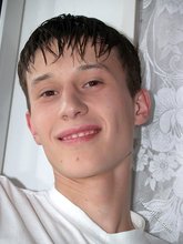 Sweaty/greasy-looking twink undressing next to a window