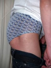 Sweaty/greasy-looking twink undressing next to a window