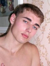 Blue-eyed twink laying on the floor and getting naked