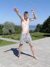Young blonde twink poses with his cock hanging out outdoors