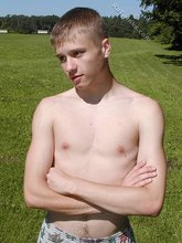 Young blonde twink poses with his cock hanging out outdoors