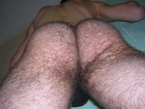 Thong-wearing hairy twink posing next to the wall
