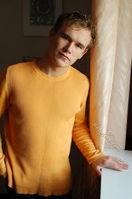 Thoughtful twink shows his six pack on a couch