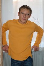 Thoughtful twink shows his six pack on a couch