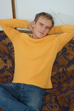 Thoughtful twink shows his six pack on a couch