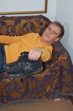 Thoughtful twink shows his six pack on a couch