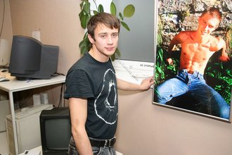 Dark-haired dude with beautiful eyes poses in his room