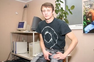 Dark-haired dude with beautiful eyes poses in his room