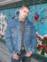 Denim-loving guy posing outdoors, looking mean/lean