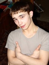 Dark-haired twink posing shirtless in his own room