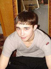 Dark-haired twink posing shirtless in his own room