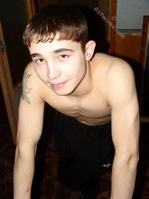 Dark-haired twink posing shirtless in his own room