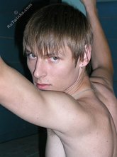 Dark-haired twink with piercing eyes showing his feet