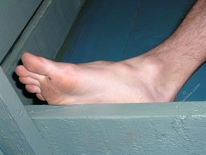 Dark-haired twink with piercing eyes showing his feet